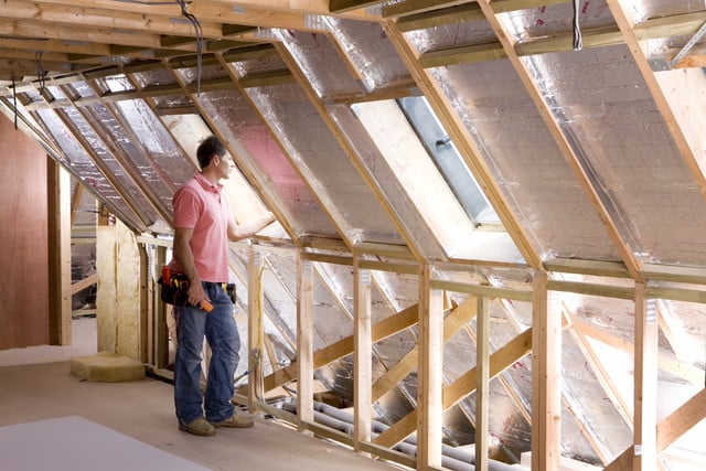 Homme qui réalise des travaux d'isolation dans ses combles aménageables